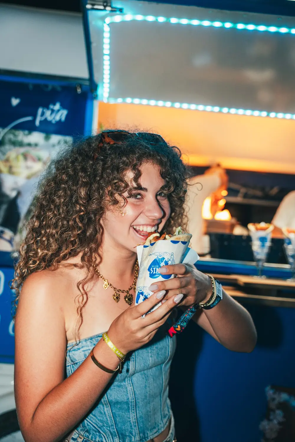 Une festivalière sourit en croquant dans sa pita