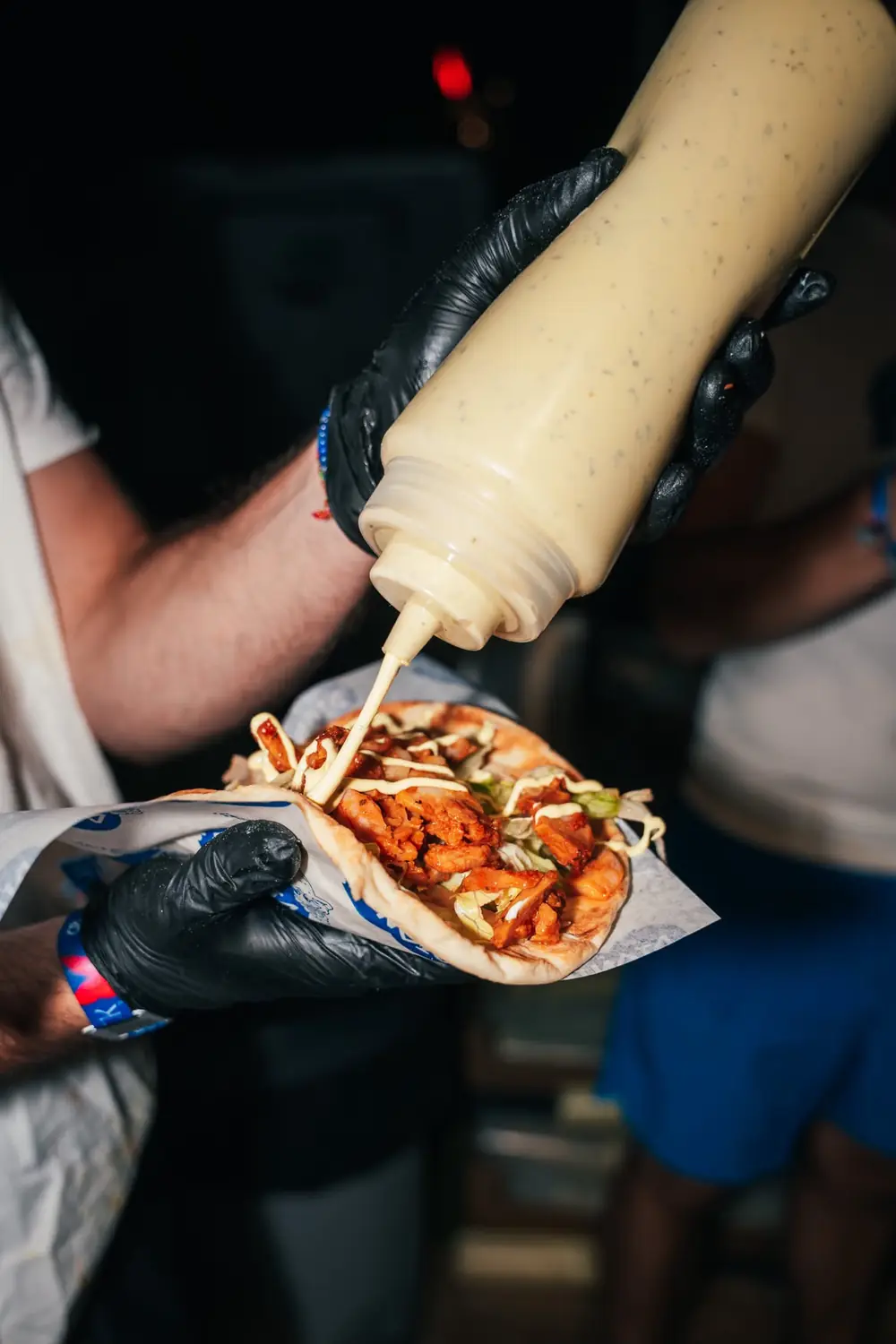 La sauce maison versée sur une pita au poulet